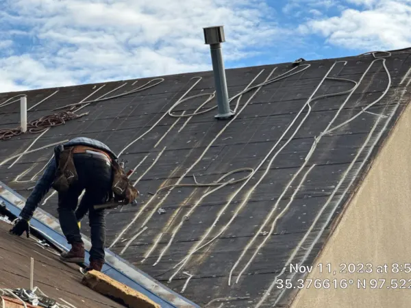 Roofing crew removing old shingles from a commercial building