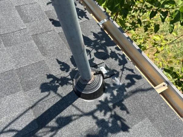 New shingles installed around a roof penetration and valley