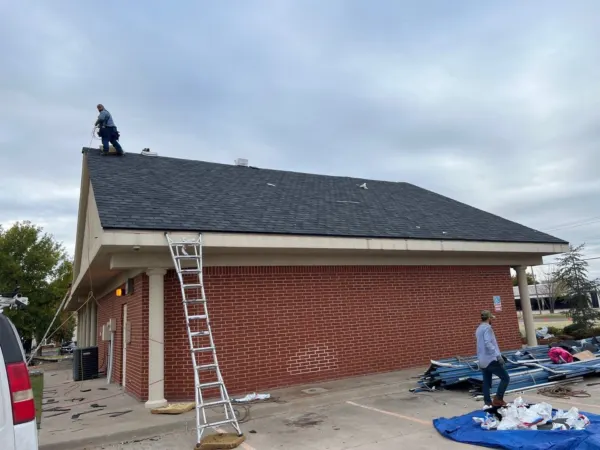 Side of the commercial building with crew finishing the roof