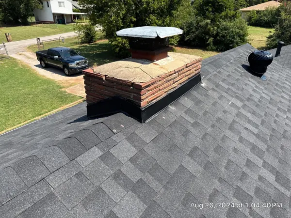 Brick chimney with new flashing on the replaced roof