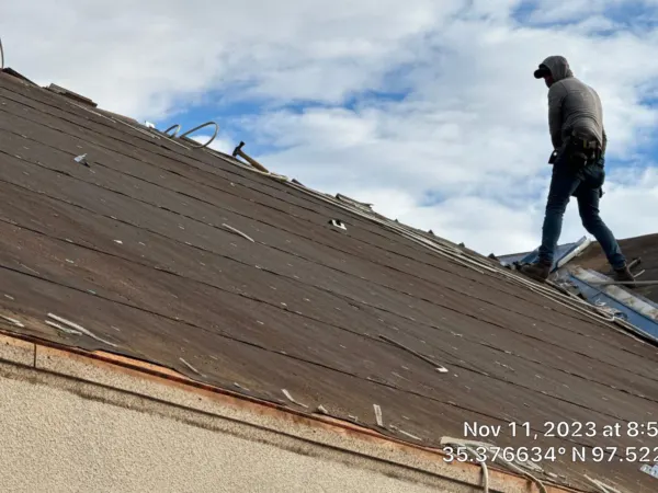 Roofer walking the commercial roof during tear-off