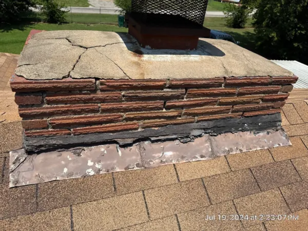 Inspection photo of worn shingle layers around a roof penetration