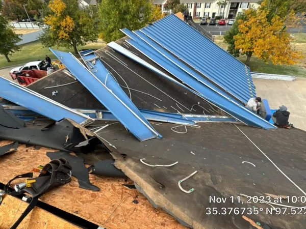 Old roofing and metal panels being removed from the commercial roof