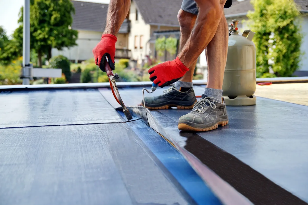 Edmond OK Flat Roof Leak Repair by Roof One using a precision torch to seal durable waterproof membrane seams on a home.