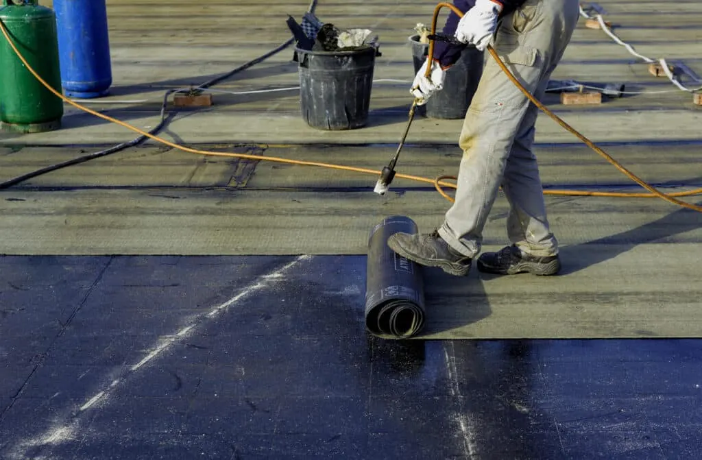 Professional Edmond OK Flat Roof Leak Repair by Roof One featuring the installation of heat-welded modified bitumen roofing.